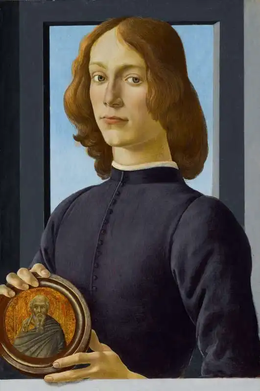 giovane uomo con in mano una medaglia di botticelli 