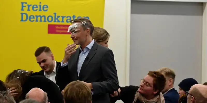 christian lindner colpito da una torta in faccia