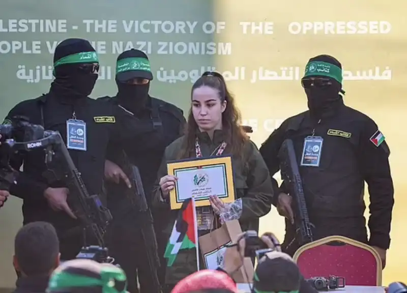 la soldatessa israeliana agam berger con il certificato di liberazione in mezzo ai miliziani di hamas  1