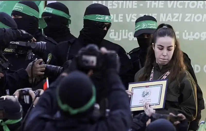 la soldatessa israeliana agam berger con il certificato di liberazione in mezzo ai miliziani di hamas 