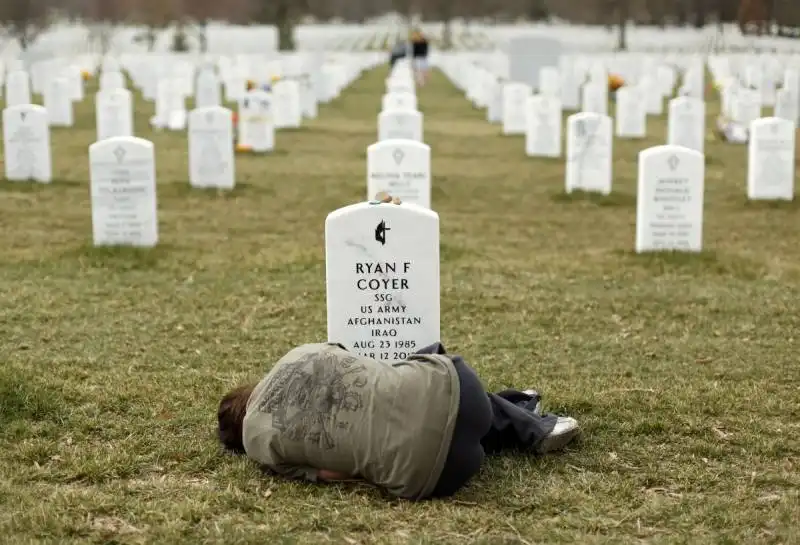 lesleigh coyer 25 of saginaw michigan lies down in front of the grave of her brother ryan coyer who served with the us army in both iraq and afghanistan