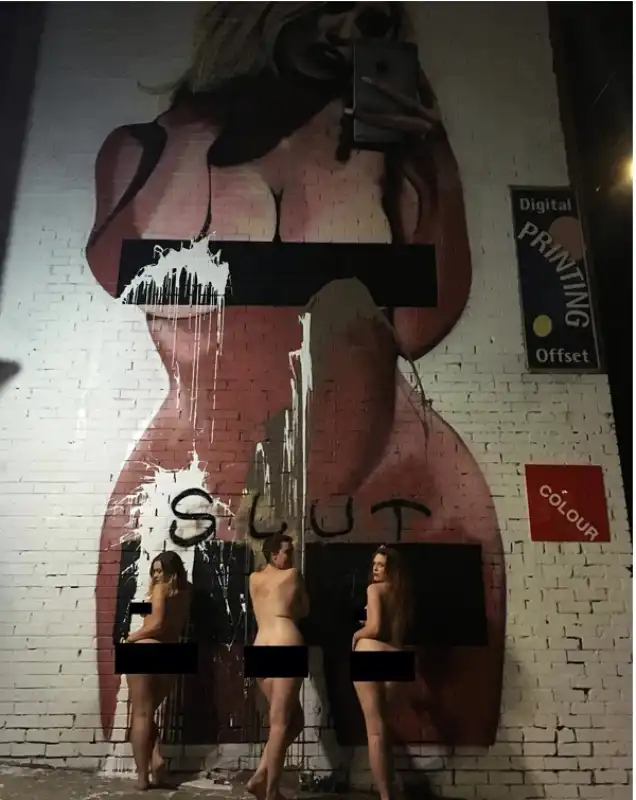 nudo di gruppo sotto il murale della kardashian