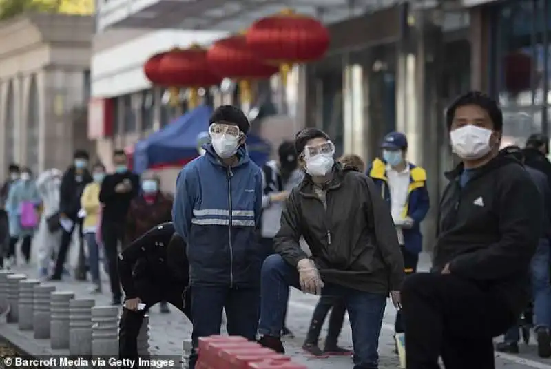 persone davanti a un ospedale di wuhan per la rilevazione della febbre