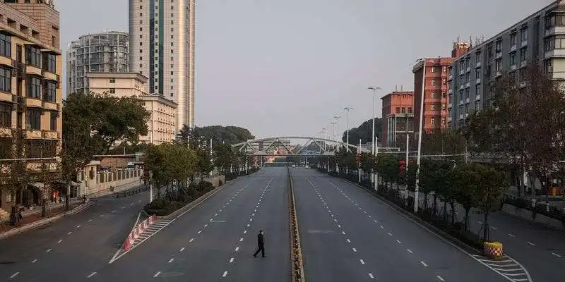 un uomo attraversa un grande viale a wuhan