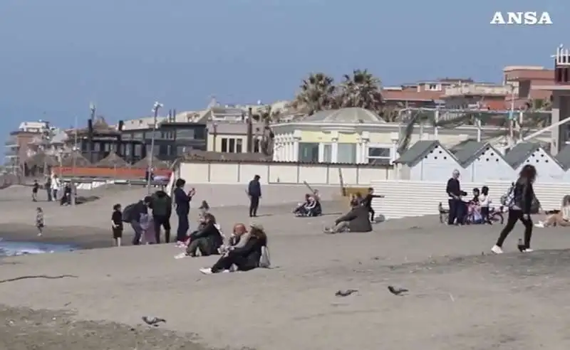 ostia, gente in spiaggia e sul lungomare  domenica delle palme