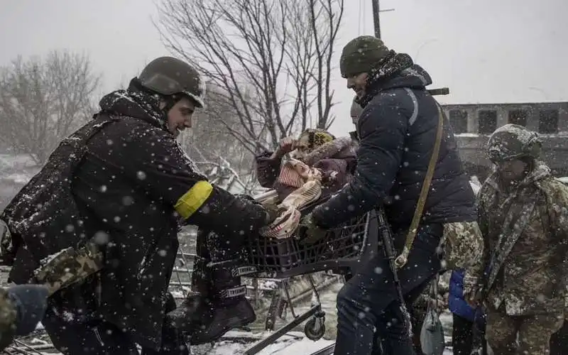 militari ucraini portano in salvo una donna a irpin 2