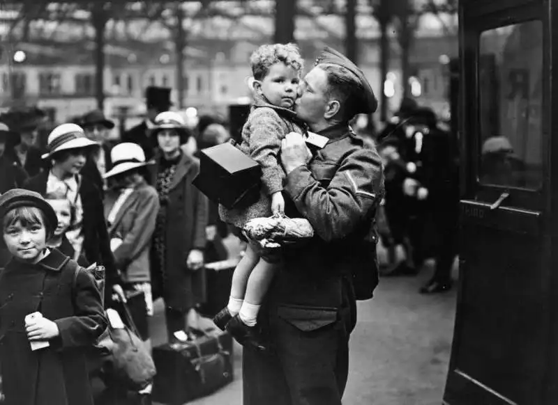 un soldato a casa in congedo dalla british expeditionary force saluta il suo bambino al punto di evacuazione, giugno 1940