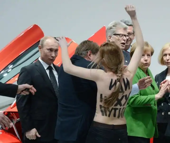 UNA DELLE FEMEN CONTESTA PUTIN ANGELA MERKEL SBIGOTTITA 