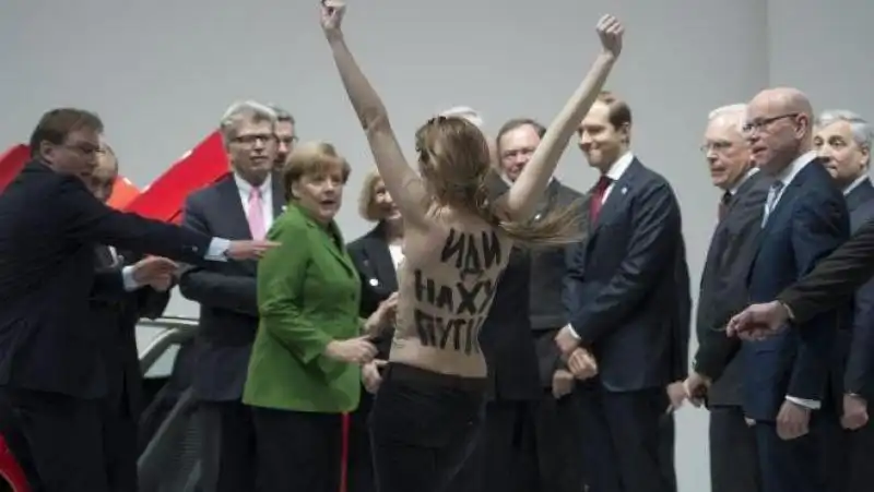 UNA DELLE FEMEN CONTESTA PUTIN ANGELA MERKEL SBIGOTTITA 