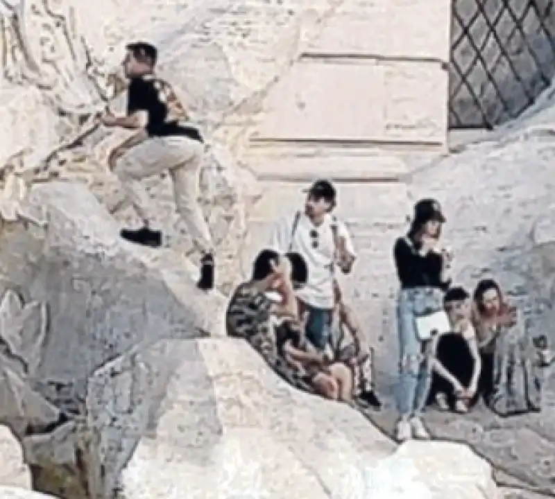 turista si arrampica sulla fontana di trevi per farsi un selfie