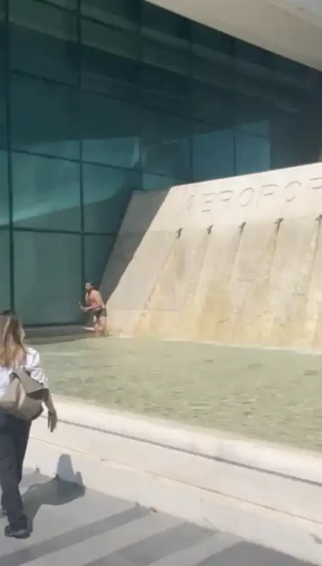 un uomo si fa la doccia nella fontana dell aeroporto di fiumicino 2