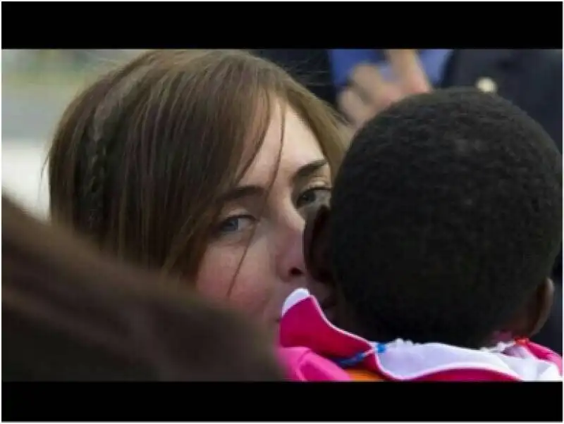 maria elena boschi guarda in camera con i bambini del congo