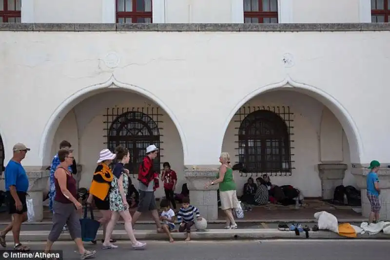 migranti in strada fra i turisti