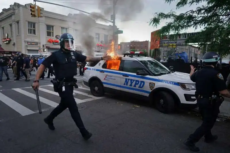 auto della polizia in fiamme