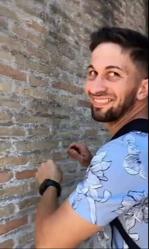 turista scrive il nome della fidanzata sul muro del colosseo