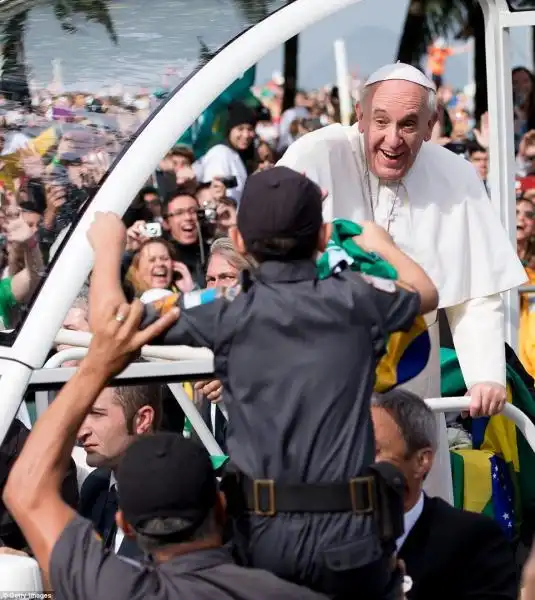 IL PAPA SORRIDE E BENEDICE IL FIGLIO DI UN POLIZIOTTO SULLA SPIAGGIA DI COPACABANA 