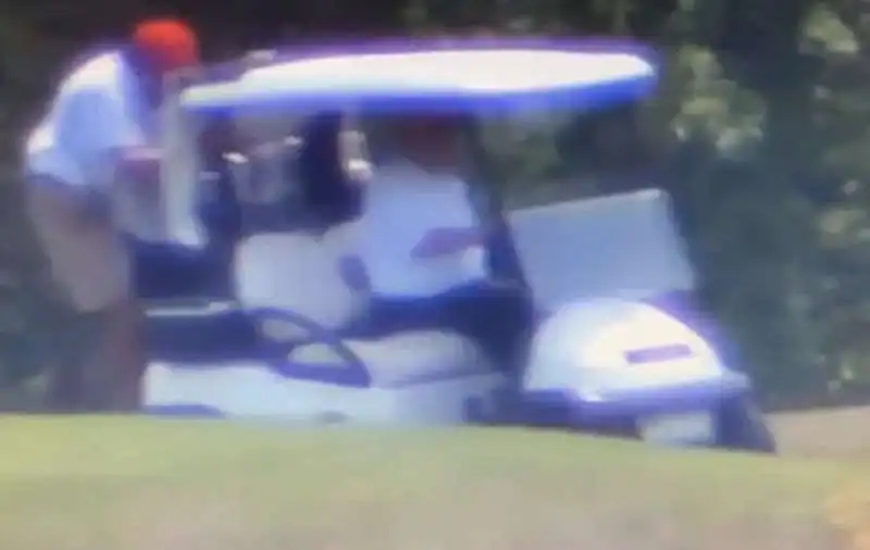 donald trump sulla golf car con il caddy aggrappato sul retro 1