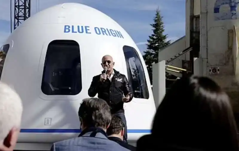 jeff bezos di fronte a una capsula di blue origin 