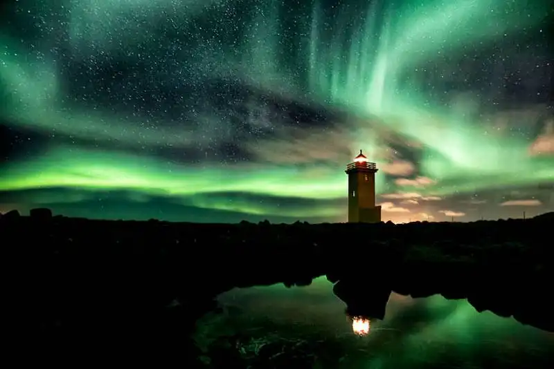 un faro nell'aurora islandese