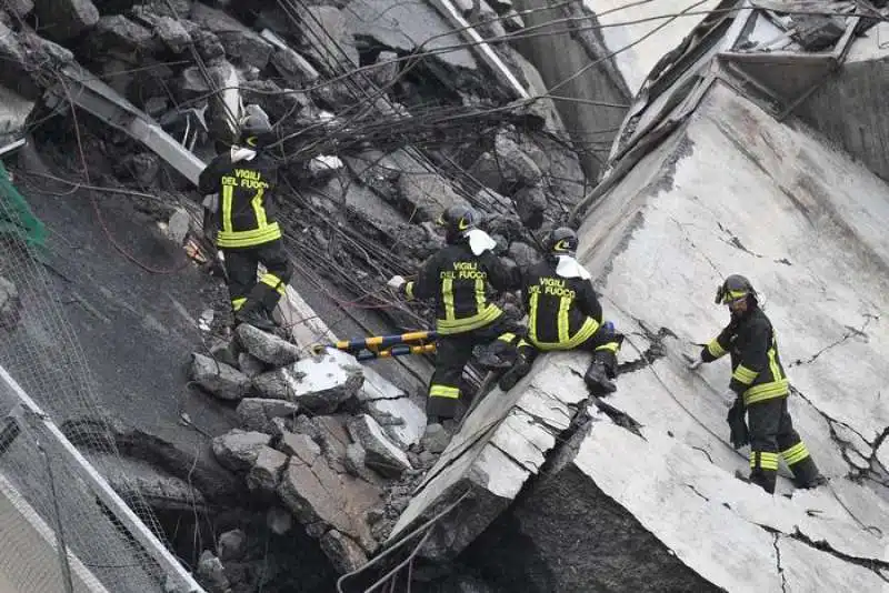 vigili del fuoco a lavoro sulle macerie del ponte morandi a genova