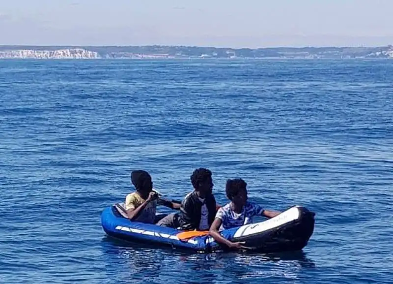 tre migranti sul canale della manica con un barchino gonfiabile 