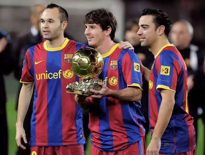 lionel messi con pallone doro tra iniesta e xavi 