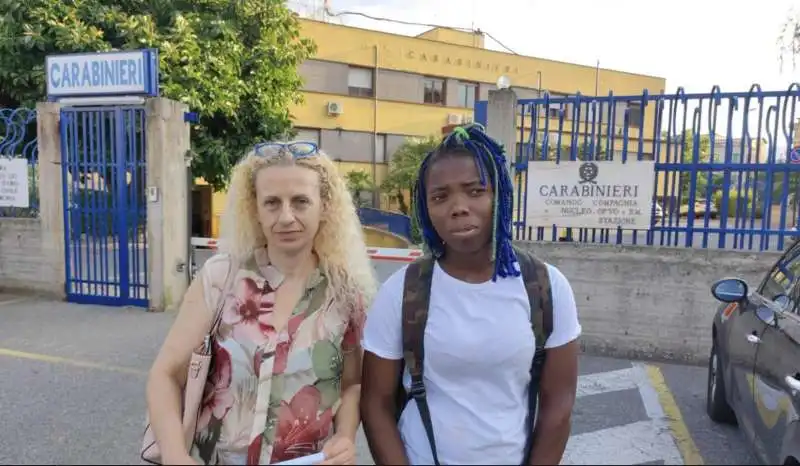 LA GIOVANE NIGERIANA BEAUTY IN COMPAGNIA DI UN'AMICA DAVANTI ALLA CASERMA DEI CARABINIERI 