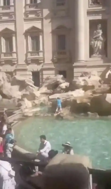 turista riempie la bottiglia d acqua nella fontana di trevi 3