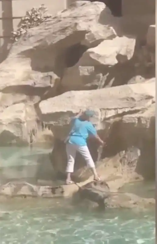 turista riempie la bottiglia d acqua nella fontana di trevi 4