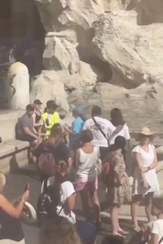 turista riempie la bottiglia d acqua nella fontana di trevi 7