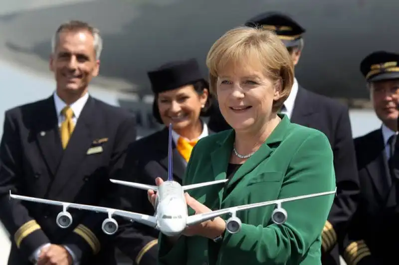 angela merkel con aereo lufthansa in mano 