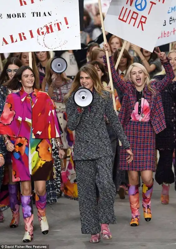 cara delevingne  alla sfilata chanel con cartelli di protesta 