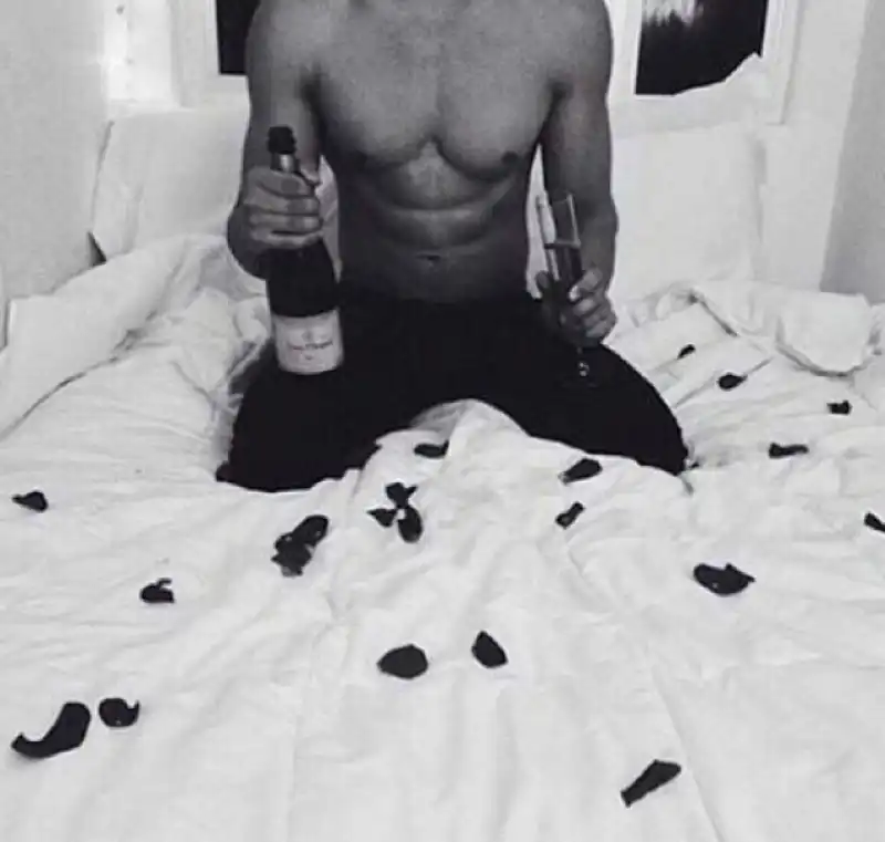 hote dude in bed con champagne