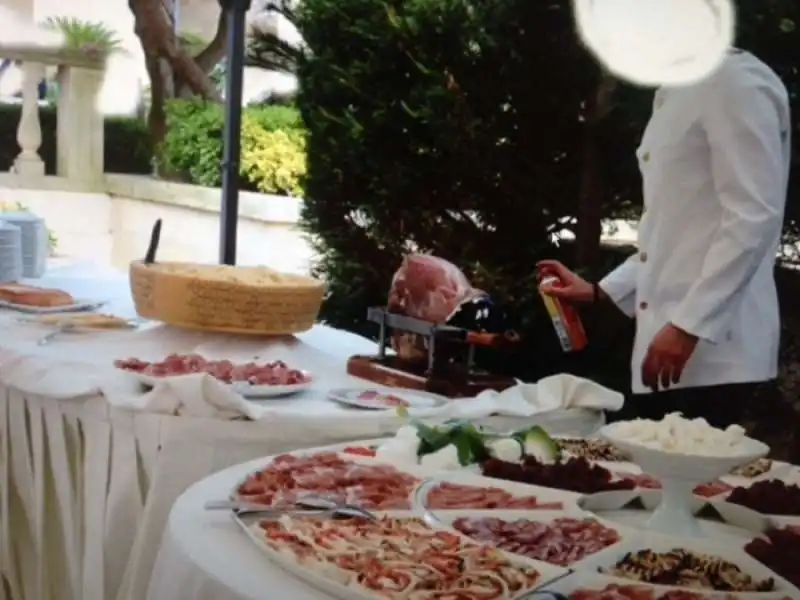 UN CAMERIERE SPRUZZA INSETTICIDA SUL BUFFET