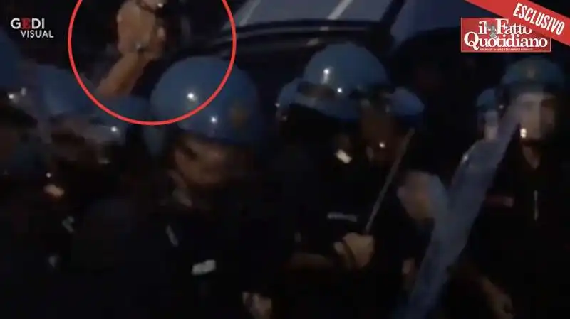 un uomo dietro la polizia riprende la manifestazione di catania nel 2018  