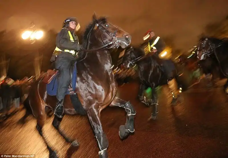 poliziotti a cavallo attaccati con petardi