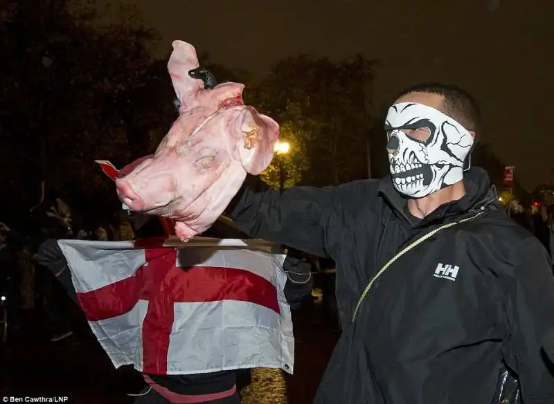 un manifestante con la testa di un maiale   il riferimento al pig gate