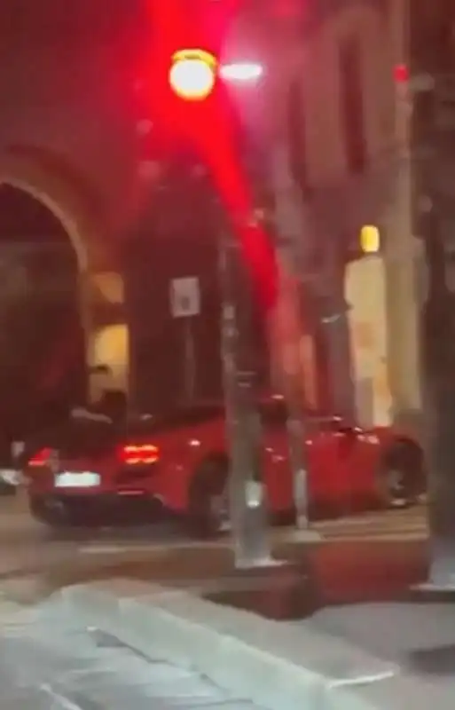 milano   ragazzo parla al telefono seduto sul cofano posteriore della ferrari   2