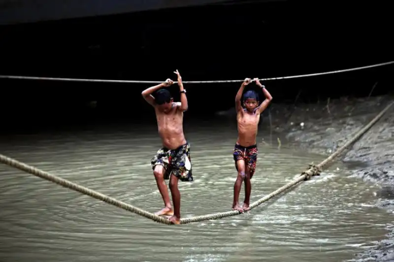 BAMBINI BIRMANI GIOCANO SU UN FIUME A RANGOON 