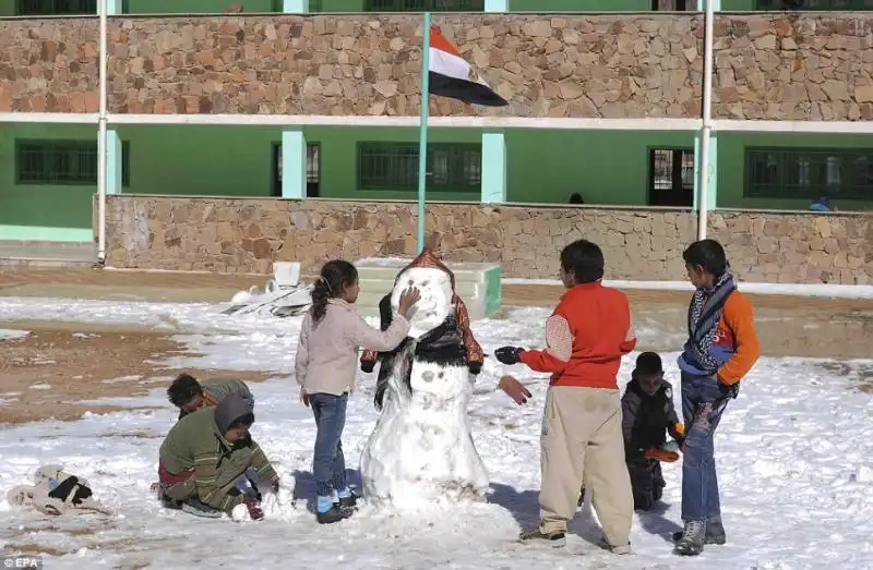 Bambini egiziani alle prese con il loro primo pupazzo di neve 