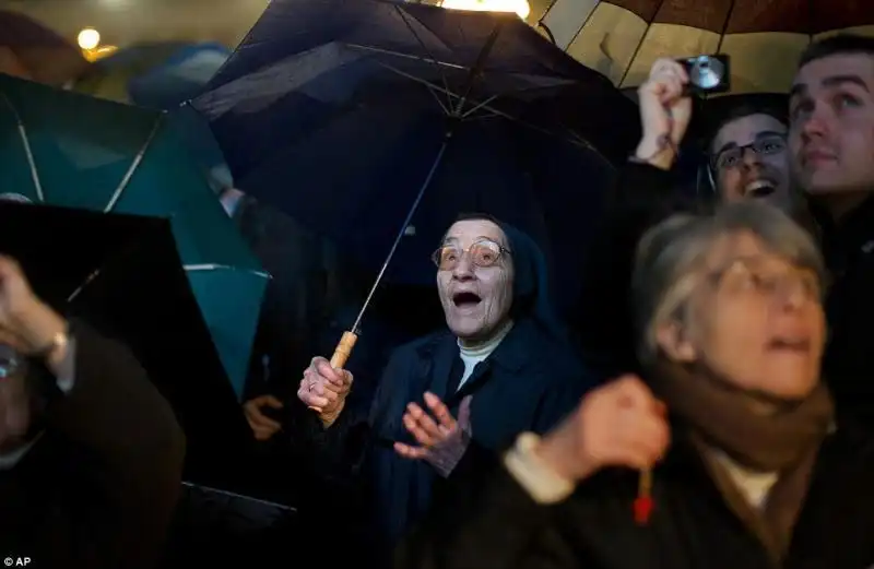 una suora che veglia in piazza San Pietro in Vaticano vede un pennacchio di fumo bianco che sorge dalla Cappella Sistina per annunciare l'elezione del nuovo papa