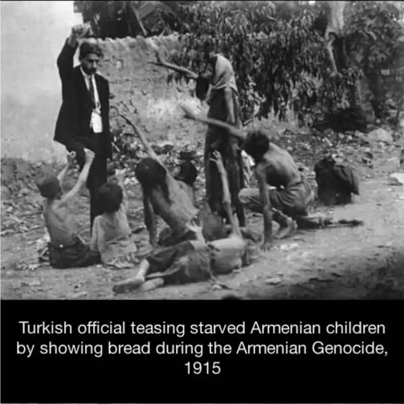 ufficiale turco con un pezzo di pane in mano prende in giro bambini armeni affamati durante il genocidio del 1915