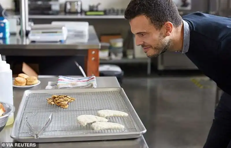 un impiegato di eat just di fronte a un petto di pollo creato in laboratorio 