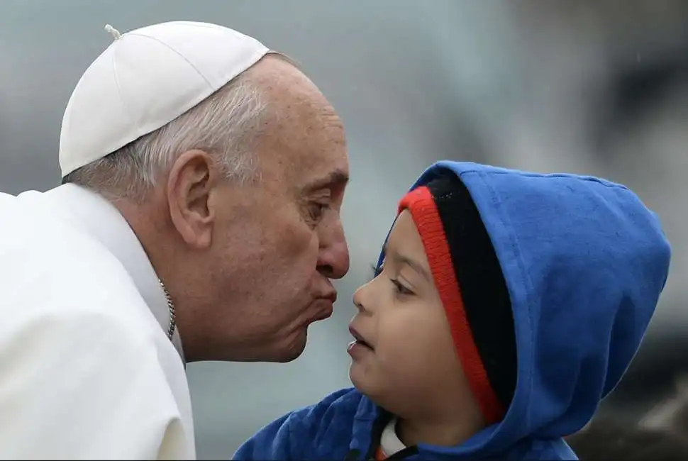 papa francesco bacia un bambino