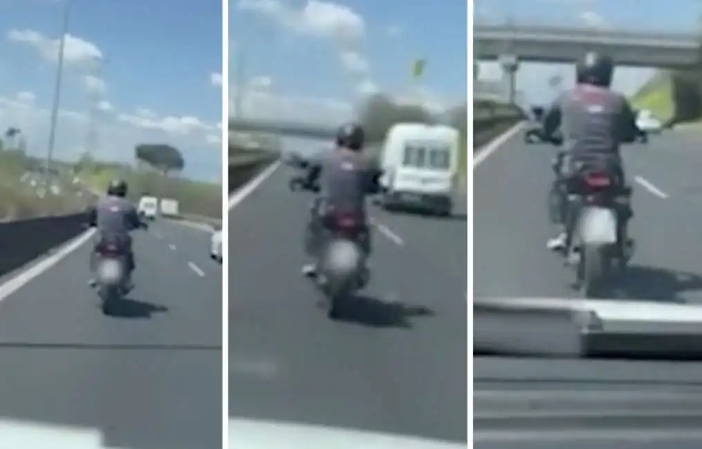 uomo in moto sul grande raccordo anulare roma macchina traffico