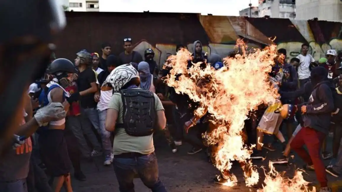 venezuela manifestante brucia