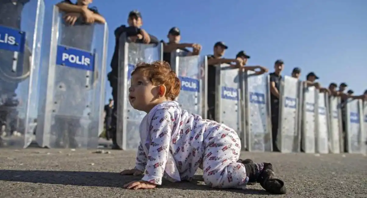 bambini davanti agli agenti con gli scudi