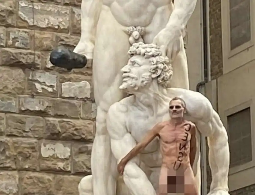 firenze - un uomo nudo sale su una statua a piazza della signoria