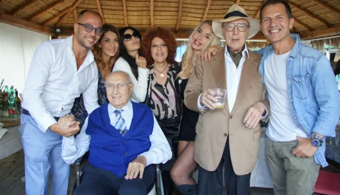 pippo baudo in sedia a rotelle al compleanno di pierfrancesco pingitore